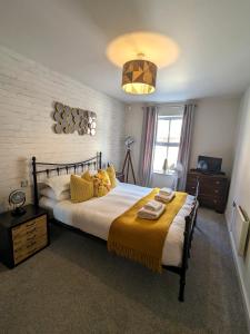 a bedroom with a large bed with yellow pillows at Russet Quarter, Parking subject to availability in York