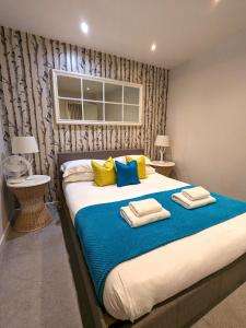 a bedroom with a large bed with blue and yellow pillows at Russet Quarter, Parking subject to availability in York