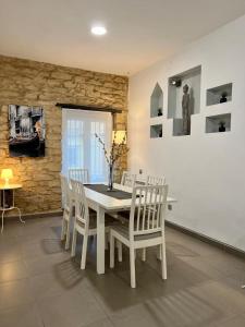 Un comedor con una mesa y sillas blancas. en DES Rustic Center, en Alicante