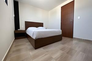 um quarto com uma cama grande e uma cabeceira em madeira em Apartaestudio CDMX, zona norte em Cidade do México