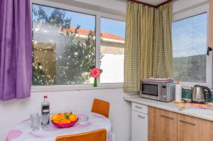 a kitchen with a table with a bowl of fruit on it at Apartments Vlado in Trogir