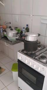 a kitchen with a stove with pots and pans on it at Apartamento Mossoró in Mossoró