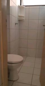 a bathroom with a toilet and a white tiled floor at Apartamento Mossoró in Mossoró +13 photos