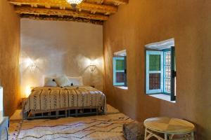 a bedroom with a bed and two windows at Agafay Desert Hotel in El Karia +125 photos