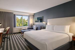 a hotel room with a large bed and a chair at Courtyard by Marriott Los Angeles Westside in Los Angeles