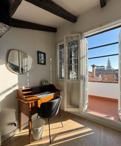 a desk and chair in a room with a window at La Favolosa casa di Amelie in Bologna