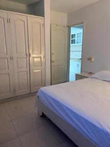 a bedroom with a white bed and a window at Playa Azul House in Bayahibe