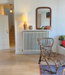 a chair in a room with a mirror and a radiator at La Favolosa casa di Amelie in Bologna