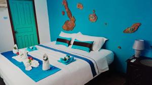 Un dormitorio azul con una cama con toallas. en Puerto Ayora Island en Puerto Ayora