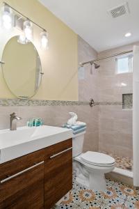 La salle de bains est pourvue d'un lavabo, de toilettes et d'un miroir. dans l'établissement Bay Harbor Lodge, à Key Largo