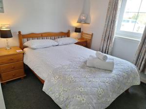 a bedroom with a bed with a towel on it at Apartment 1, Phoenix Flats in Portree