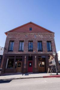ein Backsteingebäude mit einer roten Tür auf einer Straße in der Unterkunft Speakeasy Suites Sleeps 18 in Nevada City