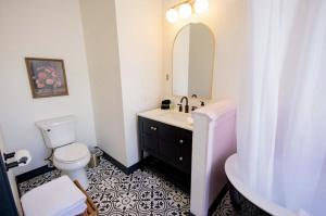 a bathroom with a sink and a toilet and a mirror at Speakeasy King Suite (Rm 8) in Nevada City