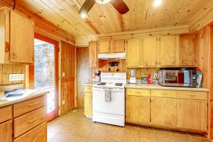 a kitchen with wooden cabinets and a white stove top oven at Life's a River in Ellijay