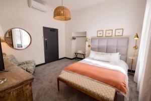 内华达城Speakeasy Queen Suite (Rm 3)的卧室里有一张床、一张沙发和一面镜子