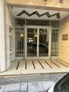 una puerta giratoria a un edificio con un coche en él en Sm Athens, en Atenas