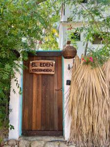 a wooden door with a sign that reads el eden escondido at El Eden Escondido in Puerto Escondido