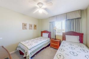 ガルフ・ショアーズにあるDriftwood Towers #5Bのベッド2台と天井ファン付きの寝室 +23枚の写真