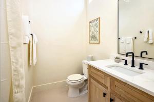 a white bathroom with a toilet and a sink at Downtown Kokopelli West 9 - Newly Remodeled Stylish Studio in Moab
