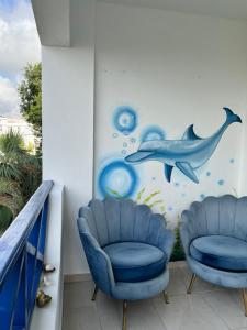 a room with two chairs and a dolphin mural at Playa Azul House in Bayahibe