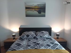 um quarto com uma cama com uma fotografia na parede em White & Black Apartament em Ełk