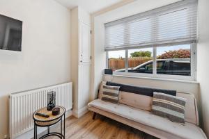 a living room with a couch and a window at The Buccleuch Luxury Apartments in Kettering