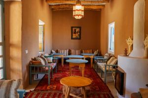 una sala de espera con mesas y sillas y una lámpara de araña en Agafay Desert Hotel, en El Karia