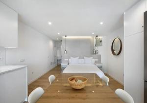 a white bedroom with a bed and a wooden table at Luxury Loft Mar y Sol 1 in Tacoronte