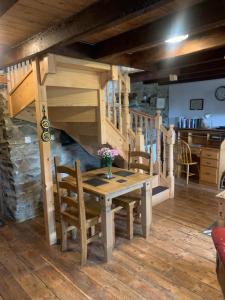 a dining room with a table and a staircase at Tanyresgair Cottages in Aberystwyth