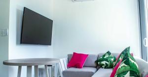 a living room with a couch and a table and a tv at The Palms Resort in Saint James