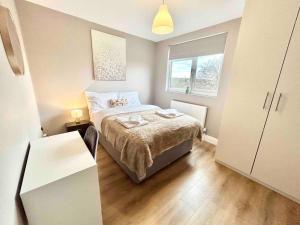a small bedroom with a bed and a window at The Winstre Borehamwood in Borehamwood