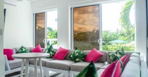 a living room with a couch with pink and green pillows at The Palms Resort in Saint James