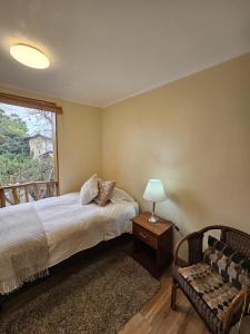 a bedroom with a bed and a window and a chair at Hotel Boutique Terra Diaguita & Spa in La Serena