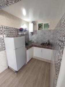 een keuken met een witte koelkast in de kamer bij small villa with garden close to the beach in Temara