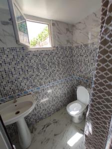 een badkamer met een wit toilet en een wastafel bij small villa with garden close to the beach in Temara