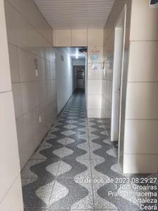 um corredor num edifício com piso em azulejo em Pousada Carimbó em Fortaleza
