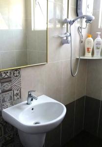 a bathroom with a white sink and a mirror at FERRINGHI HOUSE with POOL, BBQ SET, 5 MINUTES WALK to BEACH in Batu Ferringhi