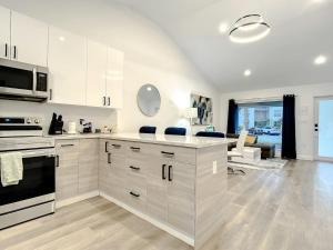 a kitchen with white cabinets and a living room at Luxe Home - Heated Pool I 5 min to Beach I BBQ Grill in Fort Lauderdale