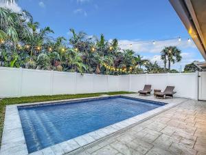 a swimming pool in the backyard of a house at Luxe Home - Heated Pool I 5 min to Beach I BBQ Grill in Fort Lauderdale