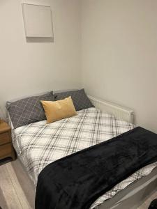 een slaapkamer met een bed met een kussen erop bij Maidstone Modern Flat High Street in Kent