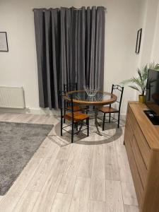 a living room with a table and chairs and a television at Maidstone Modern Flat High Street in Kent