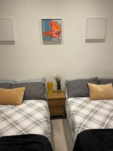 a bedroom with two beds and a picture on the wall at Maidstone Modern Flat High Street in Kent