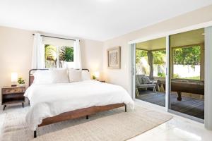 a bedroom with a bed and a balcony with a tub at Modern Bungalow near Wilton Drive I Pool Table in Fort Lauderdale