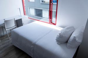 a bedroom with a white bed and a window at Esstudia 17-4 in Bogotá