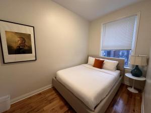 ein Schlafzimmer mit einem Bett mit einem Bild an der Wand in der Unterkunft Flexhome Wicker Park 3BR DV1 - READ INFO in Chicago