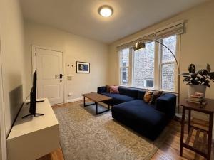 uma sala de estar com um sofá azul e uma mesa em Flexhome Wicker Park 2BR DV3 - READ INFO em Chicago