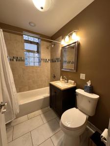 a bathroom with a toilet and a tub and a sink at Flexhome Wicker Park 2BR DV3 - READ INFO in Chicago