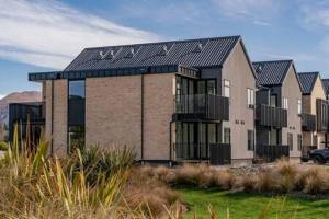 a large house with a black roof at Alps Serenity Retreat - Wanaka in Wanaka