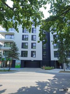 a large white building with a large parking lot at White & Black Apartament in Ełk