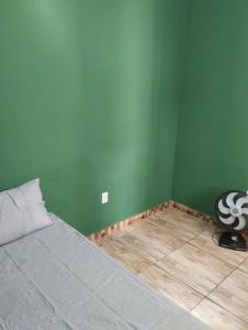 um quarto com uma cama e uma parede verde em Bela Casa em Madre de Deus 2 em Madre de Deus